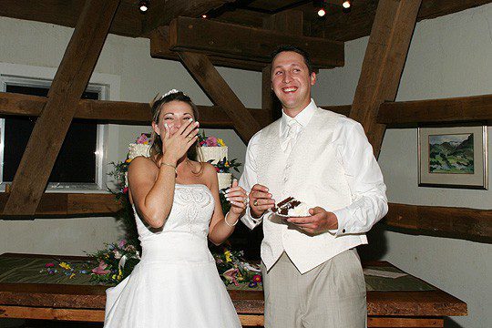 Bride laughing while eating wedding cake