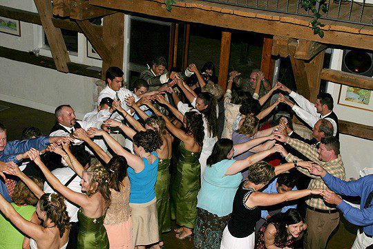 Wedding guests dance in a big line at their wedding in fredericksburg texas