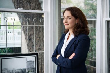 female lawyer standing in a sunroom smiling san antonio tx richard's photography