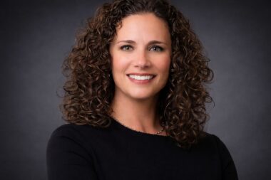 photo of woman with curly hair against dark gray backdrop san antonio